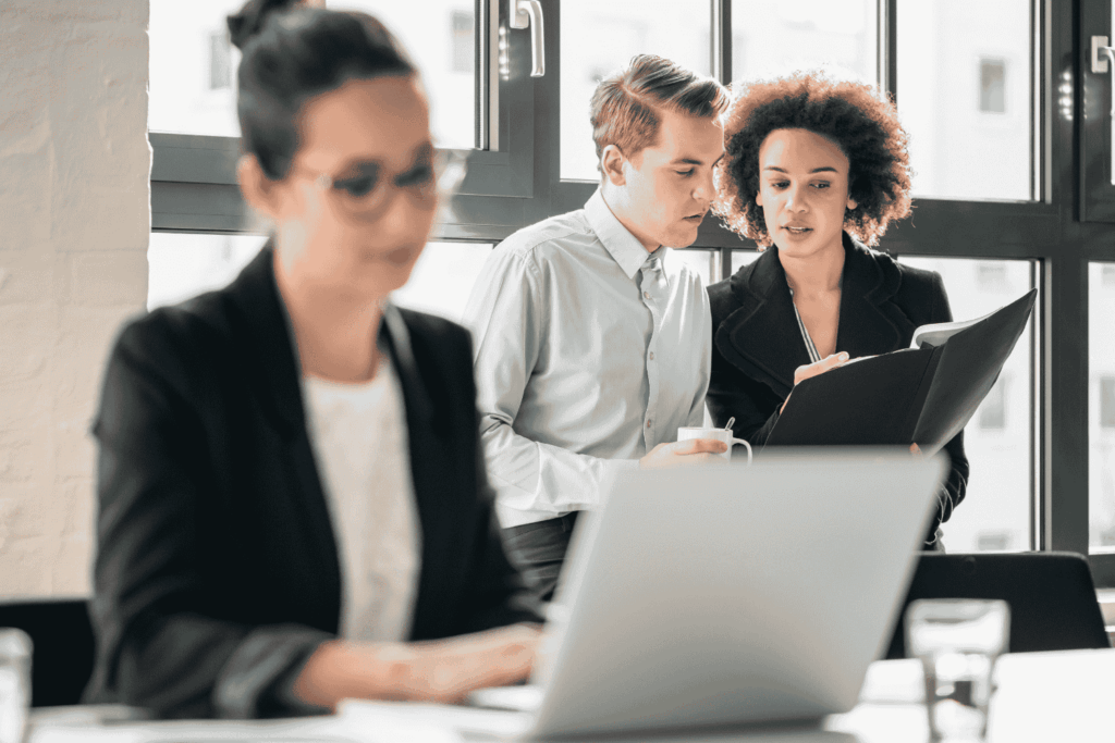 employees whispering behind a colleague's back representing internal IT security threats and the risks of employee-triggered cyber incidents