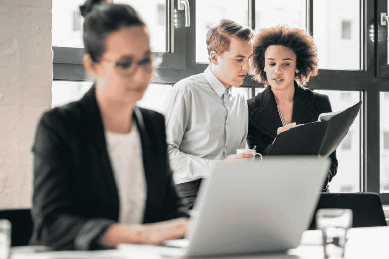 employees whispering behind a colleague's back representing internal IT security threats and the risks of employee-triggered cyber incidents