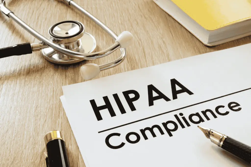 Doctor’s desk with a clipboard and stethescope displaying “HIPAA Compliance” text, representing the importance of a HIPAA risk assessment.