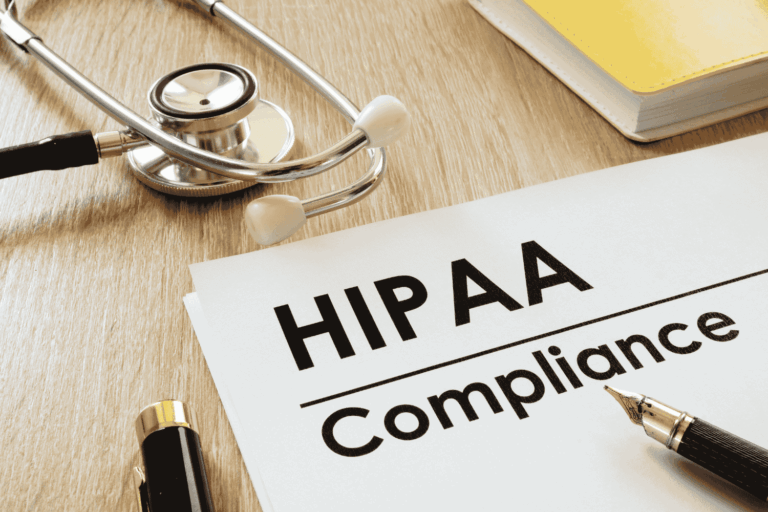Doctor’s desk with a clipboard and stethescope displaying “HIPAA Compliance” text, representing the importance of a HIPAA risk assessment.