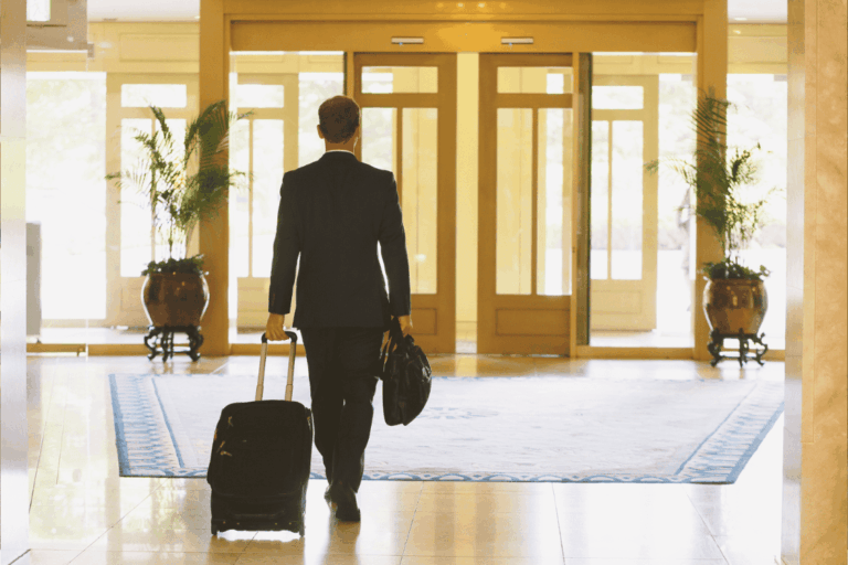 Happy hotel guest in a modern lobby, illustrating the guest experience supported by hospitality IT solutions.