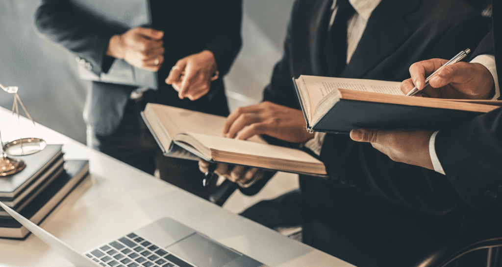 Attorney working efficiently with digital case files on a laptop while collaborating in a modern law office.